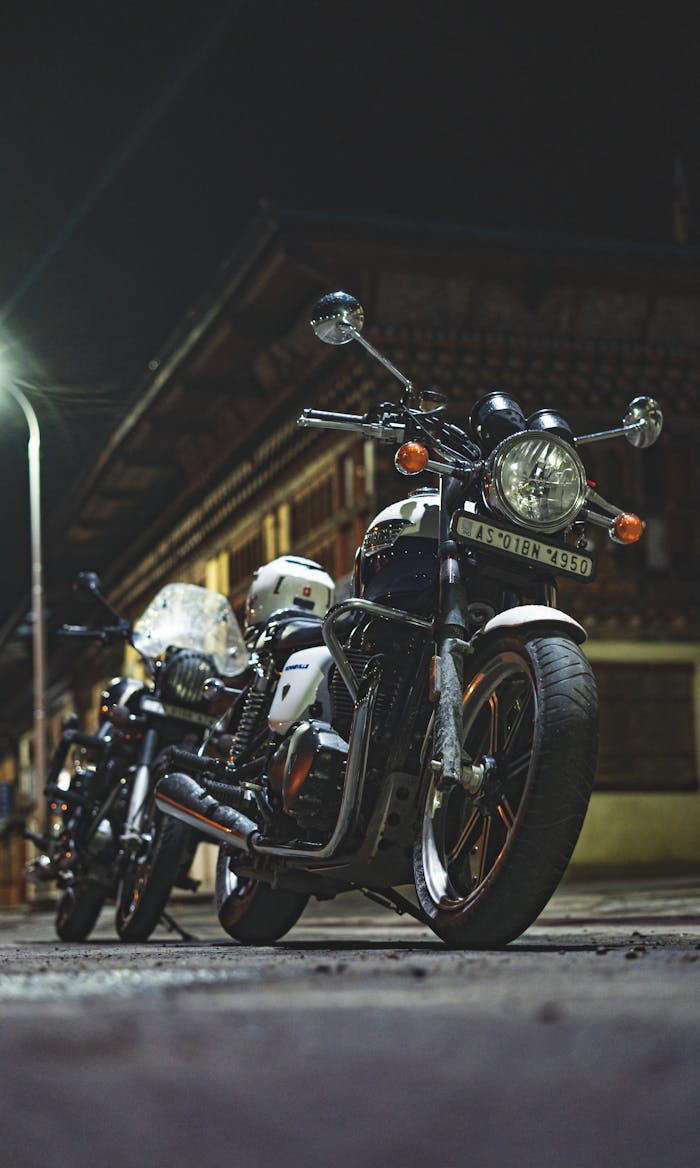 Two motorcycles parked outside a traditional building in Paro, Bhutan at night.